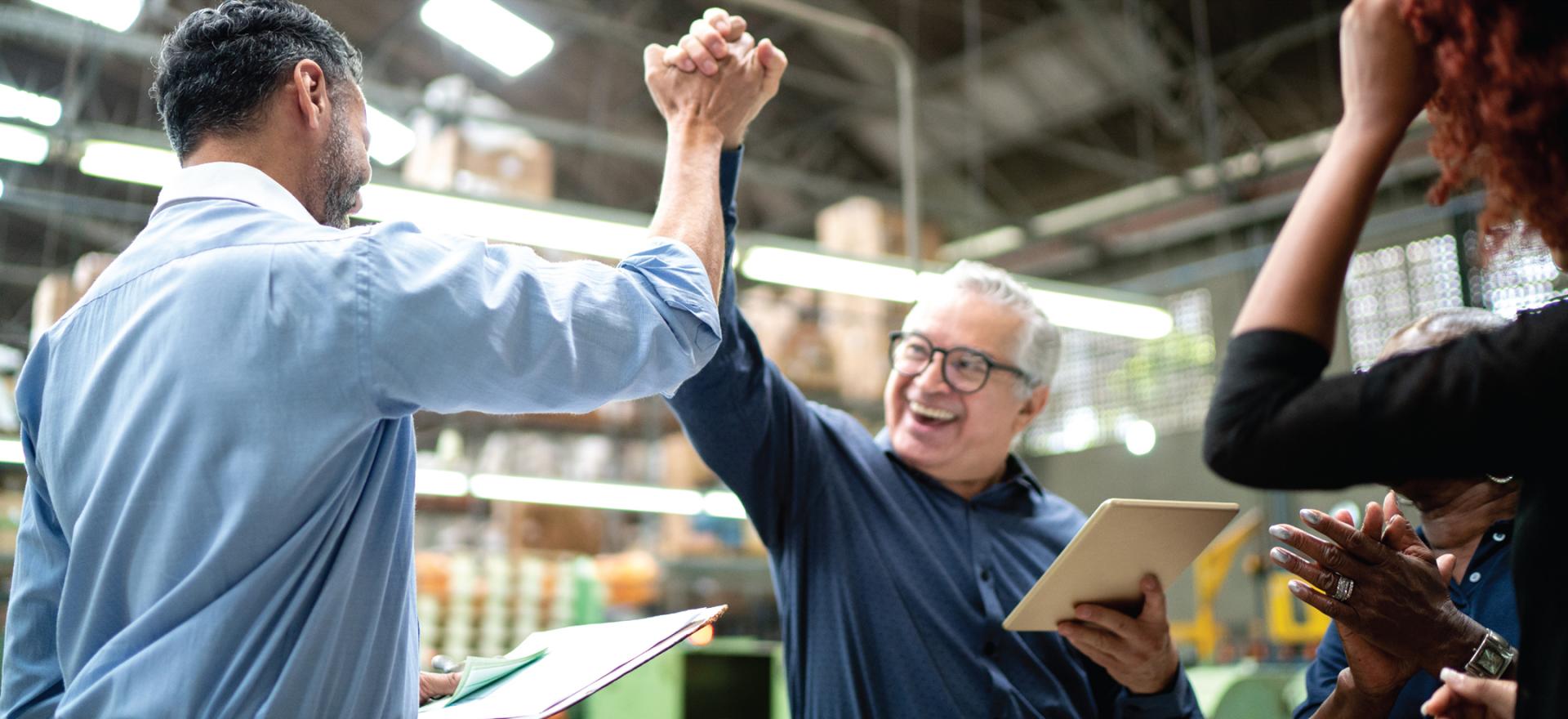 two men in a factory giving a high five