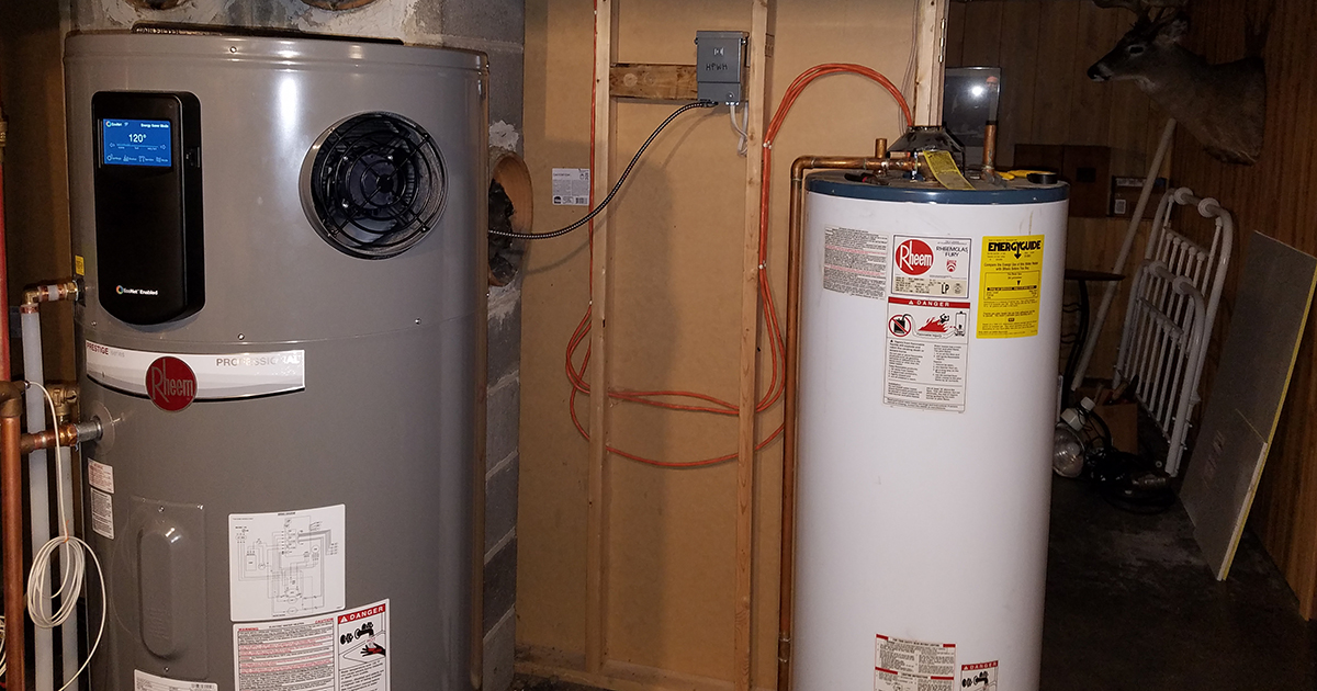 A heat pump water heater next to an old water heater