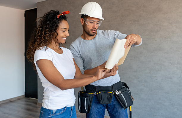 man and woman looking at blueprints