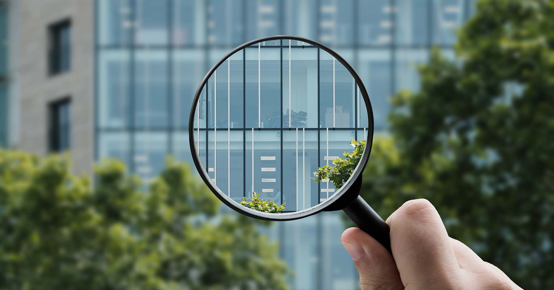 Magnifying glass looking into office building