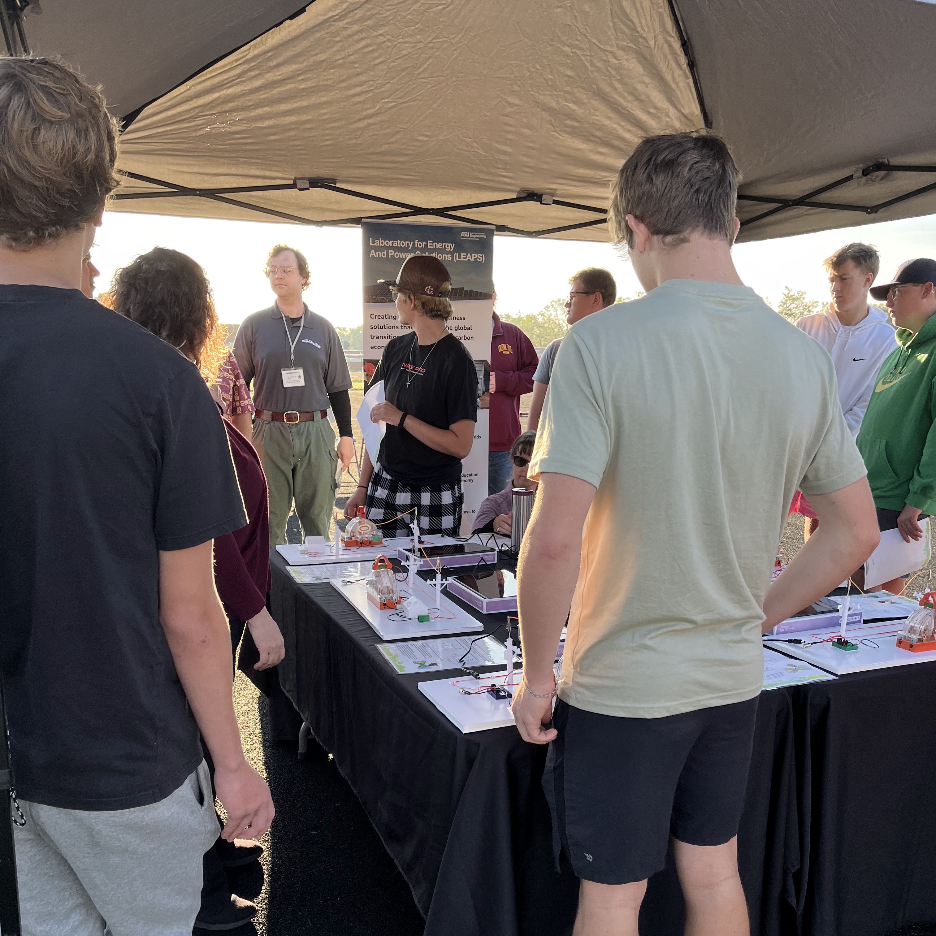 Circuit board demonstration with instructors and students watching