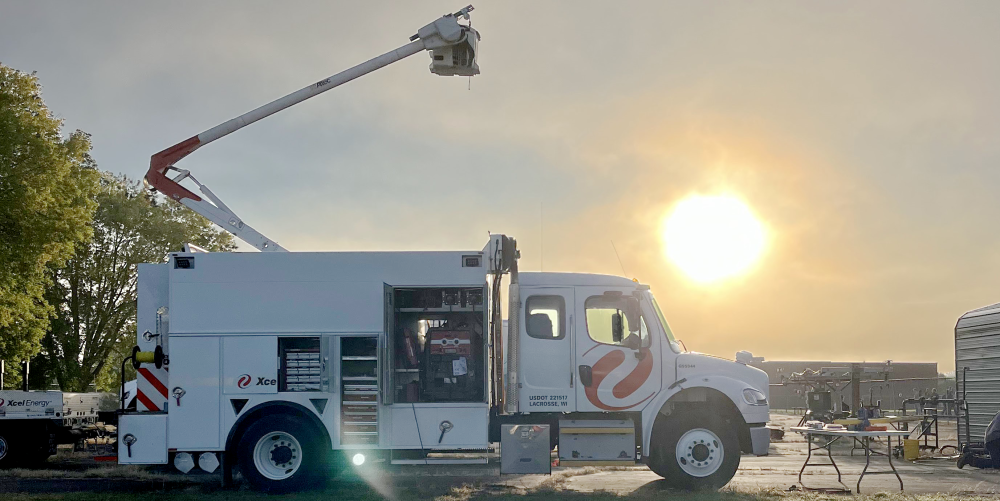 Shot of an Xcel Energy truck at sunrise with the sun in the sky behind it